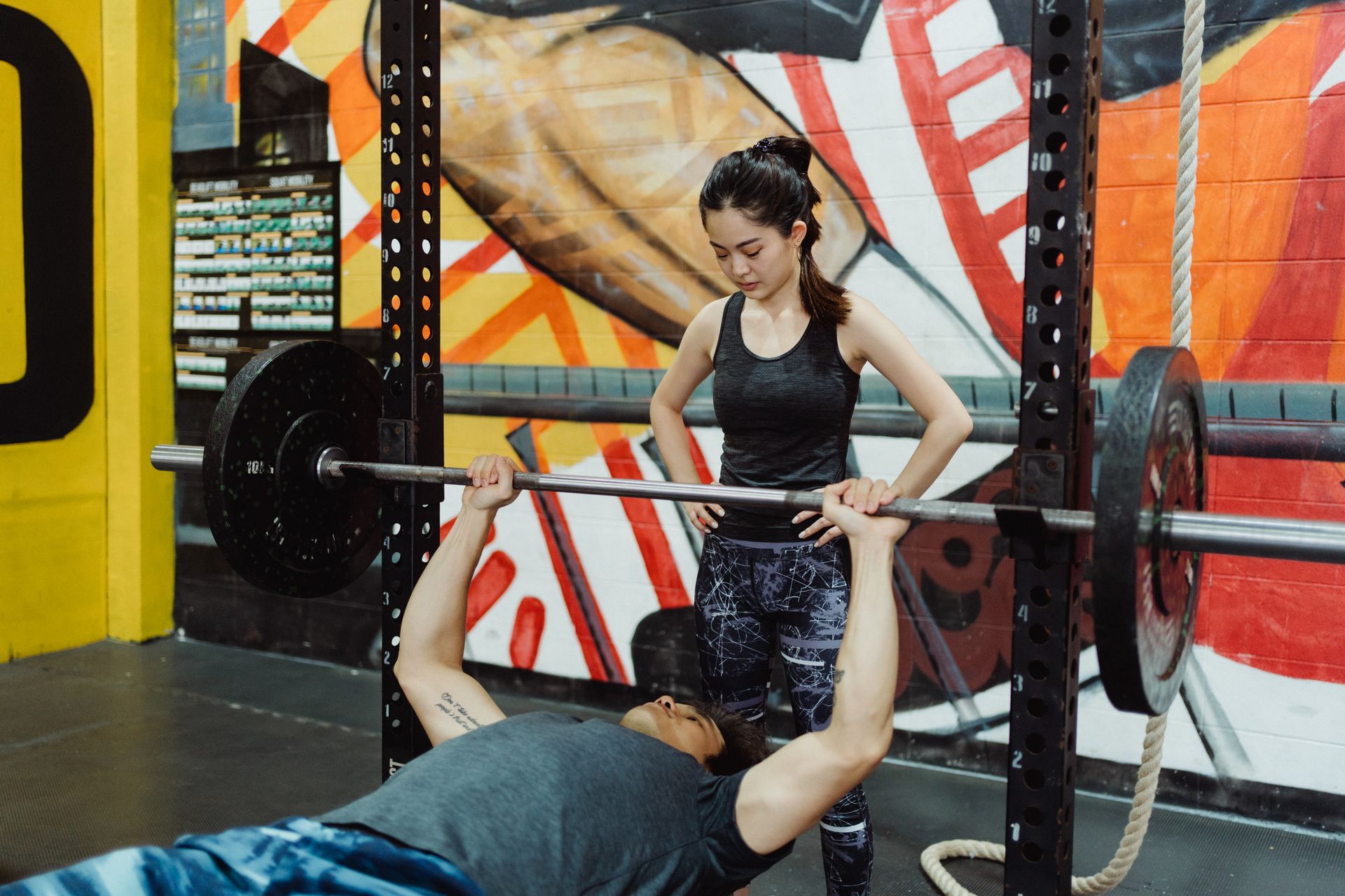 A coach spotting a client during a bench press at Stronger Body